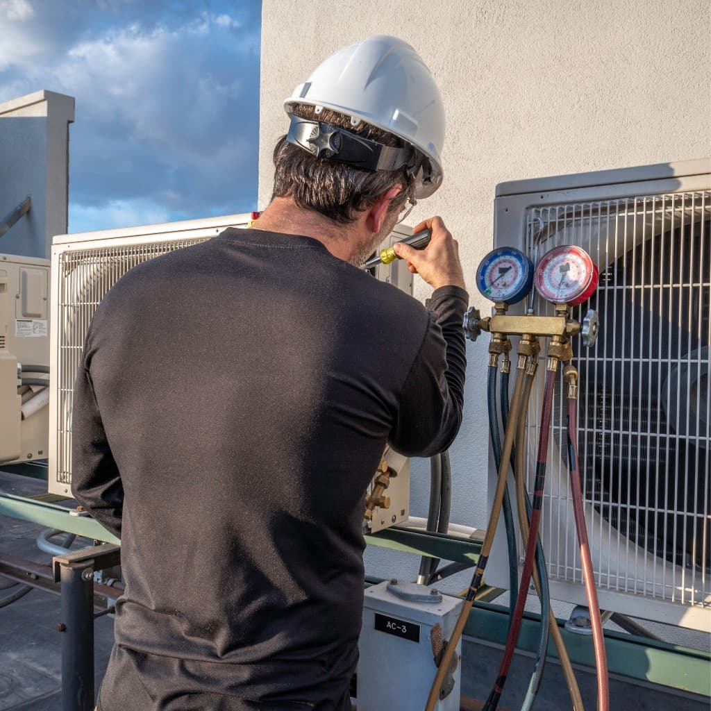HVAC technician servicing rooftop air conditioning equipment